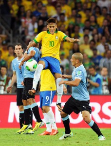  El jugador de f&uacute;tbol de la selecci&oacute;n de Brasil Neymar (c) disputa el bal&oacute;n con los uruguayos Egidio Arevalo (i) y Maximiliano Pereira (d).