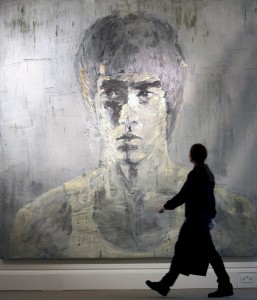 Un trabajador de la casa de subastas Sotheby's pasa junto al cuadro de Yan Pei-Ming titulado "Silver Bruce Lee" (Bruce Lee Plateado), en las instalaciones de Sotheby's en Londres. Con tres metros de altura, esta obra es la primera del genio de las artes marciales que sale a la venta en subasta.