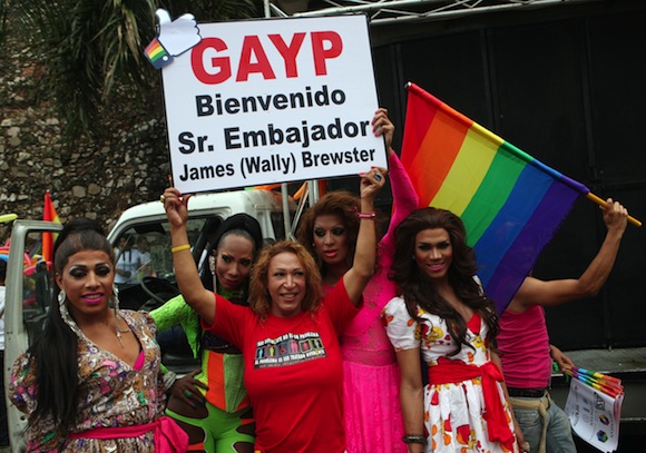 Integrantes de la comunidad LGBT sostienen un cartel que da la bienvenida a James Brewster, recién nominado embajador de Estados Unidos ante el país.