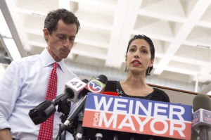 El candidato a la alcald&iacute;a de Nueva York Anthony Weiner reacciona mientras su esposa Huma Abedin (c) habla a los medios de comunicaci&oacute;n.