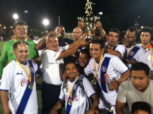 Los "Leones" del Club Olimpia recibiendo el trofeo que los identifica como nuevos campeones serie "Master" en la Jersey City Hispanic Am&eacute;rica Soccer League; entregando la copa el profesor Miguel Morante, manager de la Liga. (Foto: Cortes&iacute;a).