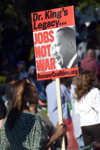 Una mujer sostiene un cartel que representa el Dr. Martin Luther King Jr., que lee "Jobs not war", durante la Marcha en Washington en el Lincoln Memorial en Washington DC.
