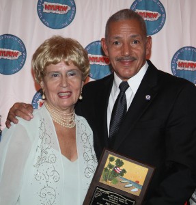 El Señor Angel Giboyeaux sonrie ogulloso al recibir el premio especial de manos de Edith Padilla presidenta de NYLPRW.