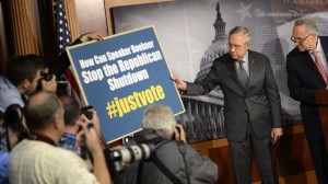  Los senadores dem&oacute;cratas Harry Reid (i) y Charles Schumer (d) muestran un cartel en el que se lee "C&oacute;mo puede el presidente de la C&aacute;mara de Representantes, (el republicano John) Boehner, parar el "cierre Republicano" durante una rueda de prensa en el Capitolio en Washington DC.
