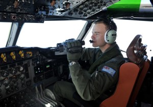 Un soldado de la Real Fuerza Aérea Australiana utiliza unos prismáticos desde un avión AP-3C Orion durante otra jornada de búsqueda del avión malasio desaparecido el 8 de marzo en el sur del Océano Índico.