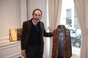 El escultor Raúl Farco con su hermosa obra “Manto” trabajada en madera y aluminio y en la parte posterior uno de sus libros de piedra, las cuales se exhiben en el Consulado General de Argentina en Nueva York.