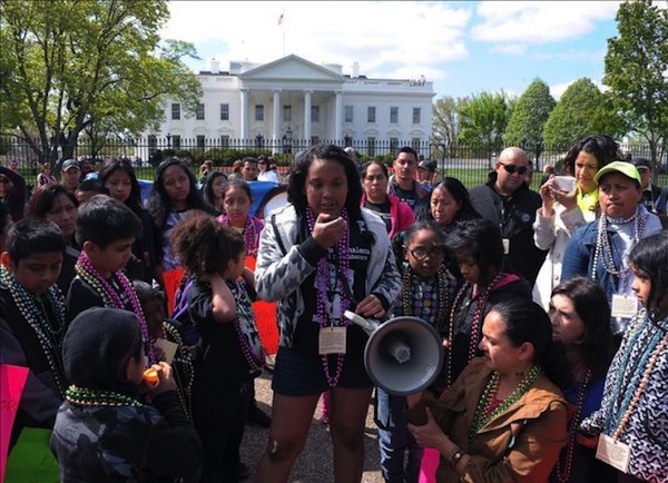 Stephany Mendoza de New Orleans habla con un micrófono delante de decenas de niños procedentes de New Orleans y Massachusetts que se manifestaron hoy frente a la Casa Blanca para exigir al presidente Obama y a los congresistas republicanos que se apruebe una reforma migratoria.