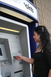 Una mujer saca dinero de su cuenta, en un cajero autom&aacute;tico. Foto Archivo.