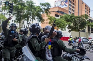 Miembros de la Guardia Nacional Bolivariana detienen a un manifestante durante una marcha de opositores hoy, lunes 12 de mayo de 2014, en el sector Las Mercedes, de Caracas (Venezuela).