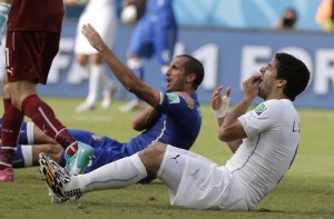 El delantero uruguayo Luis Suárez (d) en el suelo durante el partido Italia-Uruguay, del Grupo D del Mundial de Fútbol de Brasil 2014, en el Estadio das Dunas de Natal, Brasil.