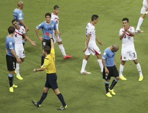  El &aacute;rbitro alem&aacute;n F&eacute;lix Brych (c) saca la tarjeta roja al defensa uruguayo Maximiliano Pereira (d), tras cometer falta al delantero costarricense Joel Campbell, durante el partido Uruguay-Costa Rica, del Grupo D del Mundial de F&uacute;tbol de Brasil 2014, en el Estadio Castel&atilde;o de Fortaleza, Brasil, hoy 14 de junio de 2014. 