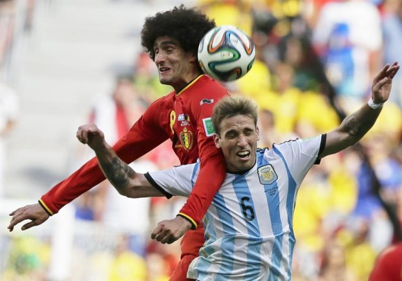 Marouane Fellaini (i) de Belgica y Lucas Biglia (d) de Argentina luchan por la bola.