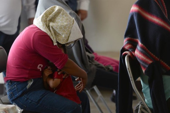 Una mujer y su hijo, parte de un grupo de deportados de EE.UU., esperan su turno para ser atendidos por las autoridades migratorias