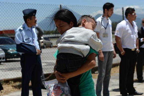 Una mujer y su hijo, quien es parte del segundo grupo de menores deportados de Estados Unidos, compuesto por 13 infantes, a su llegada a Ciudad de Guatemala, todos ellos acompañados de sus madres, desde que comenzó la "crisis humanitaria" de los niños centroamericanos que migran al norte.