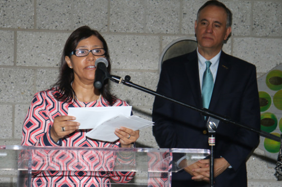 Rosa Gutiérrez, Tesorera de NPRDP, sostiene los cheques mientras anuncia los 15 estudiantes ganadores, observa el proceso Felix Matos, Presidente de Hostos Community College.
