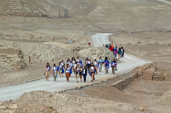 Jóvenes ruteros avanzan entre las ruinas del centro arqueológico de Pachacamac, Perú.