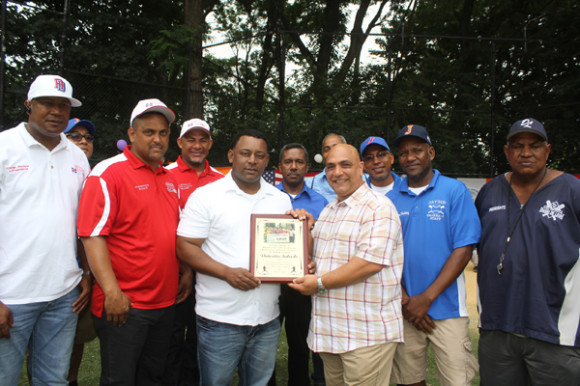 El empresario Valentín Salcedo (camisa rayas rojas), a quien está dedicado el campeonato, es galardonado por el presidente de Jaybie’s Sports Baseball José Valdez y demás acompañantes.