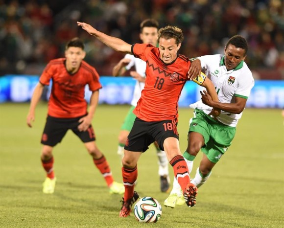 Andres Guardado (c) de M&eacute;xico ante Ramiro Ballivian (d) de Bolivia. 