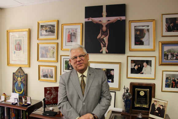  Sir Mario Paredes, Presidente de la C&aacute;mara de Comercio Chilena-Americana de Nueva York, en su oficina de la Sociedad B&iacute;blica Americana de Broadway en Manhattan, rodeado de prestigiosos reconocimientos y recuerdos de sus encuentros con los m&aacute;s altos jerarcas de la Iglesia Cat&oacute;lica mundial, jefes de estado y l&iacute;deres internacionales. 