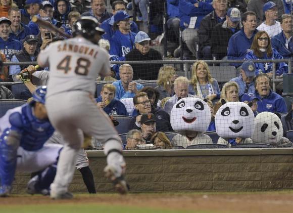 Aficionados con disfraces de oso panda observan batear al jugador de Gigantes Pablo Sandoval. 
