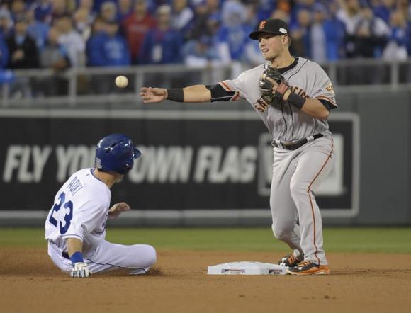Joe Panik (d) de los Gigantes en acci&oacute;n ante Nori Aoki (i) de los Reales durante el s&eacute;ptimo partido.