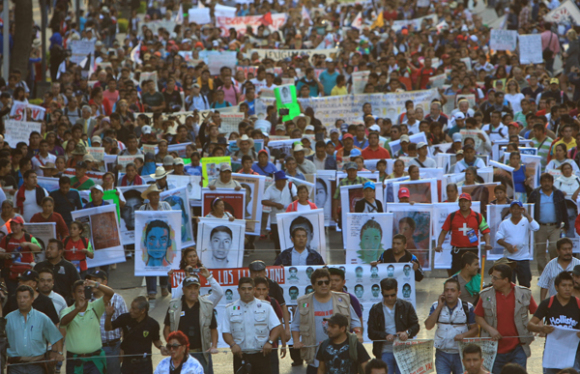 Miles de ciudadanos marchan con las fotograf&iacute;as de los 43 j&oacute;venes desaparecidos en la ciudad de Iguala. 