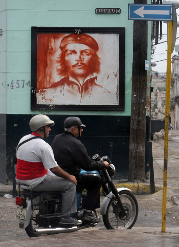Dos hombres se movilizan en una moto frente a una imagen del líder revolucionario Ernesto Ché Guevara. La relajación en EE.UU. de las restricciones de viaje a Cuba dinamizarán las visitas de estadounidenses a la isla y tendrá un "impacto muy positivo" en las relaciones bilaterales, según agencias de viaje y expertos.