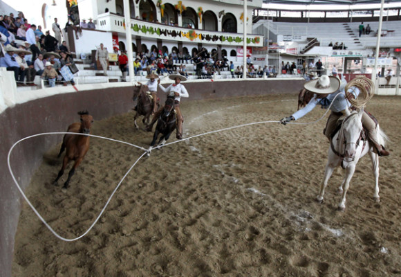 Unos charros ejecutan suertes con sus reatas en el marco del D&iacute;a del Charro en la ciudad de Guadalajara.