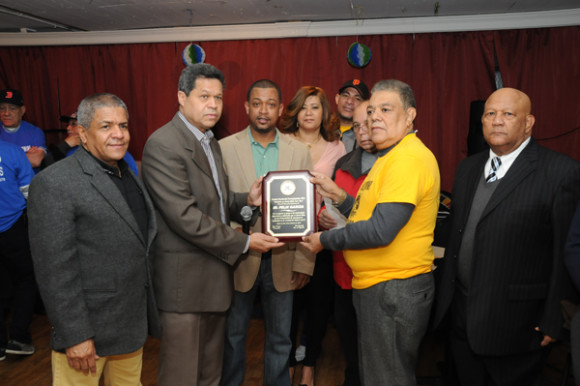 De izquierda a la derecha: Williams Veloz, el ingeniero Jesús Burgos, junto a José González, secretario de Deporte y Máximo Padilla, entregaron una placa de reconocimiento a Félix García, por las actividades deportivas y culturales que ha podido desarrollar dentro de las comunidades de Yasigueros, radicados en Nueva York.