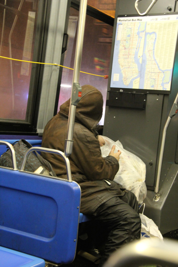  Mendigo revisando la basura en un autob&uacute;s de la linea 5 que recorre la Quinta Avenida.
