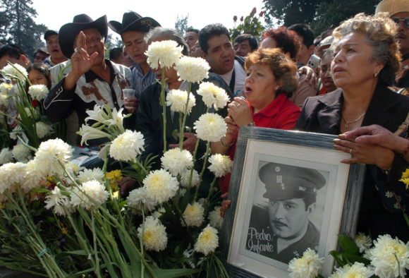 Seguidores del actor y cantante mexicano Pedro Infante muestran carteles con su foto en su tumba del pante&oacute;n Jard&iacute;n en Ciudad de M&eacute;xico.