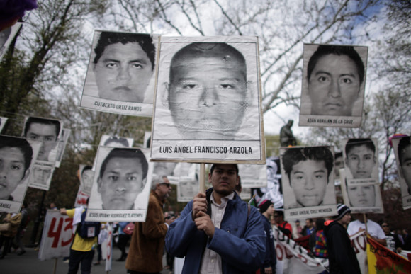 Un hombre sostiene un cartel con el rostro de uno de los 43 estudiantes mexicanos desaparecidos durante una marcha hacia la sede de las Naciones Unidas al cumplirse siete meses de su desaparici&oacute;n, en Nueva York.