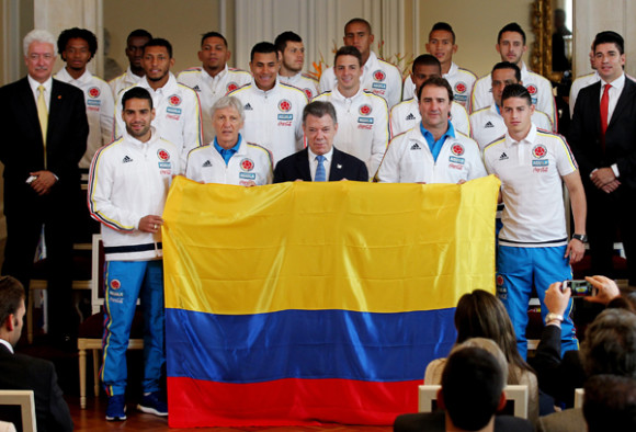 l presidente de Colombia, Juan Manuel Santos (c), entrega la bandera nacional a los jugadores de la selección colombiana de fútbol que participará en la Copa América, Chile 2015 el pasado 29 de mayo de 2015, durante un acto en Bogotá (Colombia).