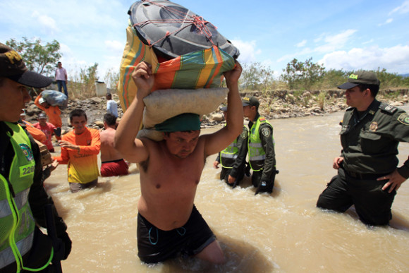 Cientos de colombianos cargan sus pertenencias por el río Táchira desde Venezuela hacia el sector La Parada (Colombia).