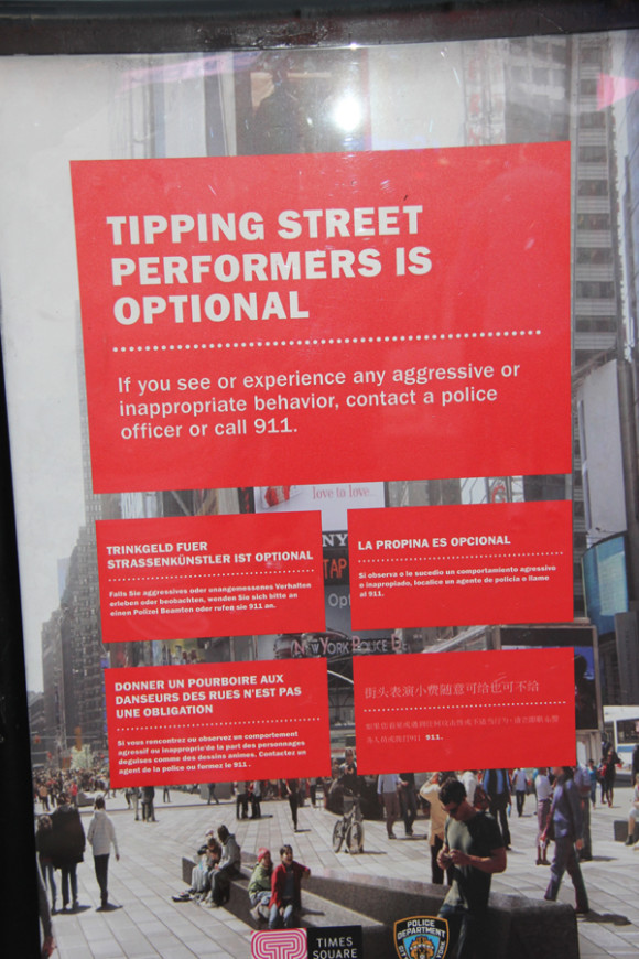 Un letrero en varios idiomas alerta a los turistas que no están obligados a dar propinas (tips) a los personajes de Times Square.