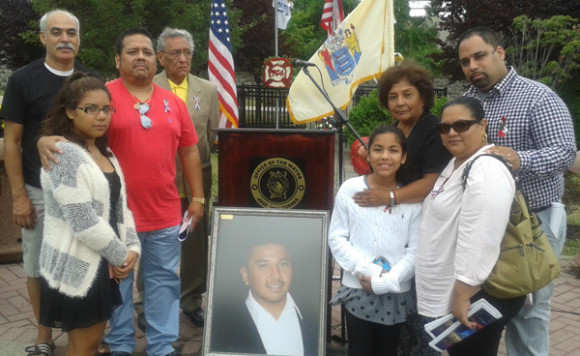 Marina Arévalo, con la foto de su hijo Kenneth Lira, su padre Jose Lira, su hermano Michael y sus familiares más cercanos (Foto cortesía Javier Cabrera)