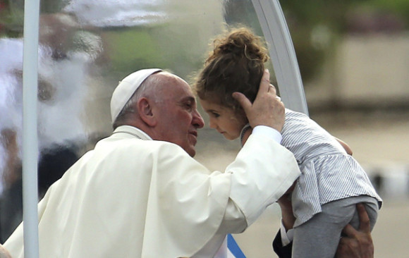 El papa Francisco a su llegada en el pam&oacute;vil a la Plaza de la Revoluci&oacute;n de La Habana, el 20 de septiembre, para oficiar su primera misa en Cuba, a la que asistir&aacute;n miles personas que ya est&aacute;n congregadas en el que se considera uno de los lugares m&aacute;s emblem&aacute;ticos del pa&iacute;s.En la foto, besa a una ni&ntilde;a a la que hiceron llegar al papam&oacute;vil.