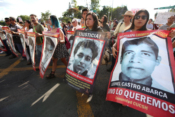 Miles de personas marchaaron con pancartas en calles de Guadalajara, México para recordar el aniversario de la desaparición de 43 estudiantes de la Escuela Normal Rural de Ayotzinapa, que hace un año fueron secuestrados por policías corruptos del municipio mexicano de Iguala.