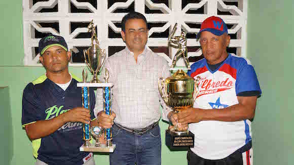 El diputado de la provincial Espaillat, Carlos Garc&iacute;a, entrega el trofeo de campe&oacute;n al dirigente de Mao y el de subcampe&oacute;n al equipo de Santiago, de la 4ta Copa Internacional de Beisbol que es celebrada en su honor. (Foto Jos&eacute; Luis Paulino)