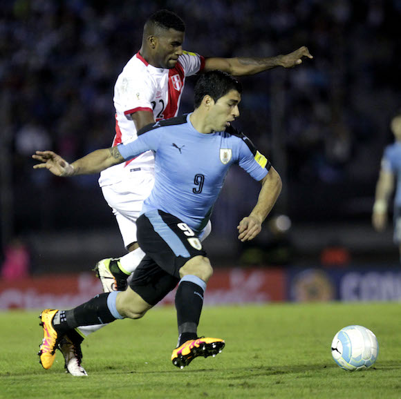 El jugador de Uruguay Luis Su&aacute;rez (d) disputa el bal&oacute;n con Carlos Ascuez (i) de Per&uacute; en un partido contra Per&uacute; por las eliminatorias suramericanas para Rusia 2018 en el estadio Centenario de Montevideo, Uruguay.