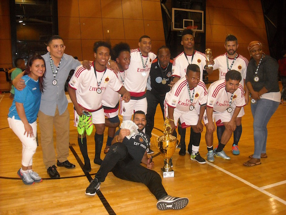 El Sula F.C. mostrando el trofeo que los identifica como los 'flamantes' campeones de la Primera categoría en la Liga Sport HonduBronx. Con ellos (extremo izquierdo), Vera Zambrano y Javier Chavez, presidente/fundador de la Liga. (Foto Buki Chapin)