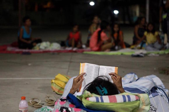 Fotograf&iacute;a de la noche del lunes 18 de abril y disponible hoy, martes 19 de abril, de una mujer que lee una biblia en una pista de baloncesto, tras el fuerte sismo de 7,8 grados que sacudi&oacute; al pa&iacute;s en Manta (Ecuador) el pasado s&aacute;bado 16 de abril. En la zona se han identificado 93 de 95 fallecidos rescatados hasta ahora y se cuentan al menos 421 heridos.