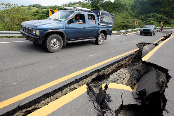 Veh&iacute;culos transitan por una v&iacute;a averiada hoy, lunes 18 de abril de 2016, tras un fuerte sismo de 7,8 grados en la carretera entre Pedernales y Jama en el sector de Punto Palmar (Ecuador). El n&uacute;mero de personas fallecidas a causa del terremoto que el pasado s&aacute;bado azot&oacute; la zona tropical del norte de Ecuador se eleva a 413, seg&uacute;n inform&oacute; el Ministerio Coordinador de Seguridad en un comunicado.