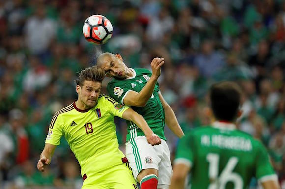 El jugador venezolano Christian Santos (i) disputa el bal&oacute;n con el mexicano Jorge Torres (d) hoy, lunes 13 de junio de 2016, durante el partido entre M&eacute;xico y Venezuela por el Grupo C de la Copa Am&eacute;rica 2016, en Houston, Texas. El resultado final fue 1-1. 