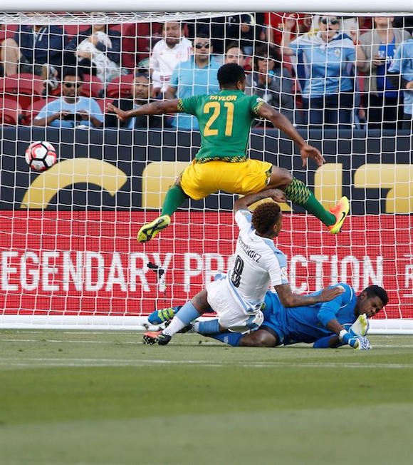 El jugador uruguayo Abel Hernández (c) anota un gol ante el portero jamaiquino Andre Blake (d) y el defensor Jermaine Taylor (i) hoy, lunes 13 de junio de 2016, durante un partido entre Uruguay y Jamaica por el Grupo C de la Copa América Centenario, en Santa Clara, California.
