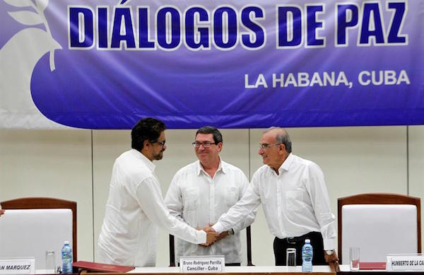El segundo jefe de las FARC y líder de los delegados de la guerrilla, Luciano Marín (i), alias "Iván Márquez"; saluda al jefe de la delegación de paz del Gobierno colombiano, Humberto de la Calle (d); junto al canciller cubano, Bruno Rodriguez (c), hoy, miércoles 24 de agosto del 2016, en La Habana (Cuba), donde se firmó el acuerdo final de paz para todos los colombianos.