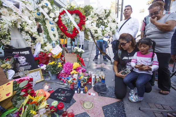 Un grupo de personas rinden tributo a Juan Gabriel, una de las estrellas musicales m&aacute;s importantes de Latinoam&eacute;rica, en su estrella en el Paseo de la Fama en Hollywood, Estados Unidos, que ha sido lugar de peregrinaje tras su fallecimiento y que se ha llenado de flores, velas y l&aacute;grimas.