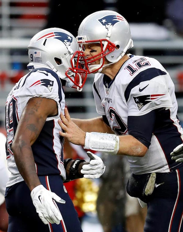 El mariscal de campo de New England Patriots, Tom Brady, recibe a Malcolm Mitchell (L)