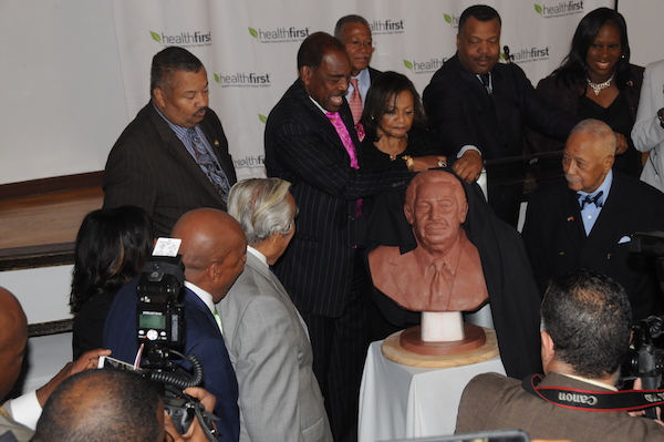 Momento en que reverendo Bishop Cecil G.Riley, acompañado del concejal Inés Dickens, el exalcalde David Dinkins, George Hulse, vicepresidente de Healthfirst, reverendo Dennis AA. Dillon y el comunitario activista Robert Jackson, develó el busto en arcilla en honor a Rangel.