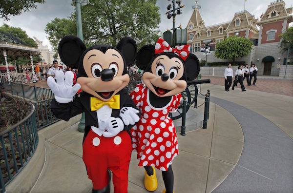 Actores disfrazados de los personajes de Disney Mickey (izda) y Minnie Mouse saludan al fotÛgrafo en el parque tem·tico de Disney en Hong Kong, China.